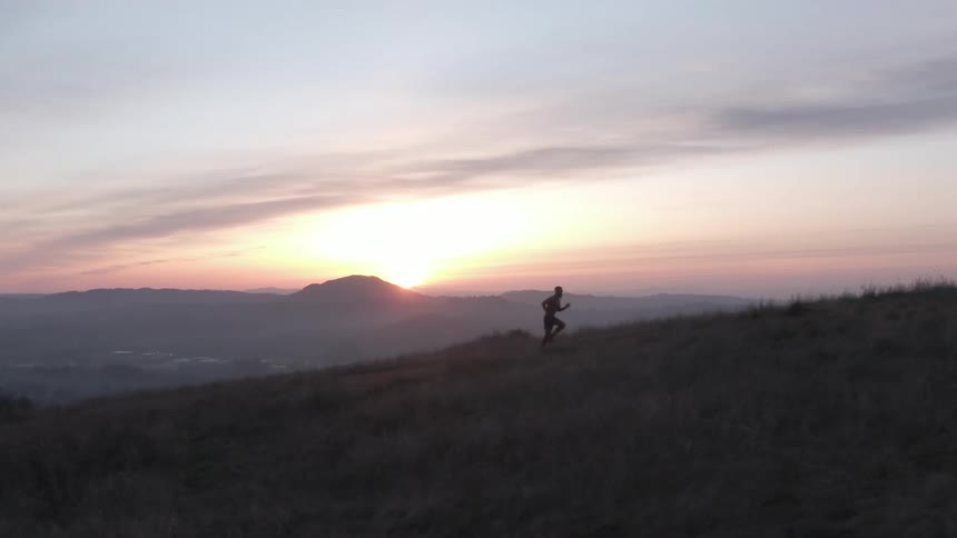A man runs on the mountain as the sun rises