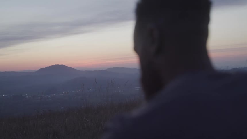 Man on a mountain peak at sunrise