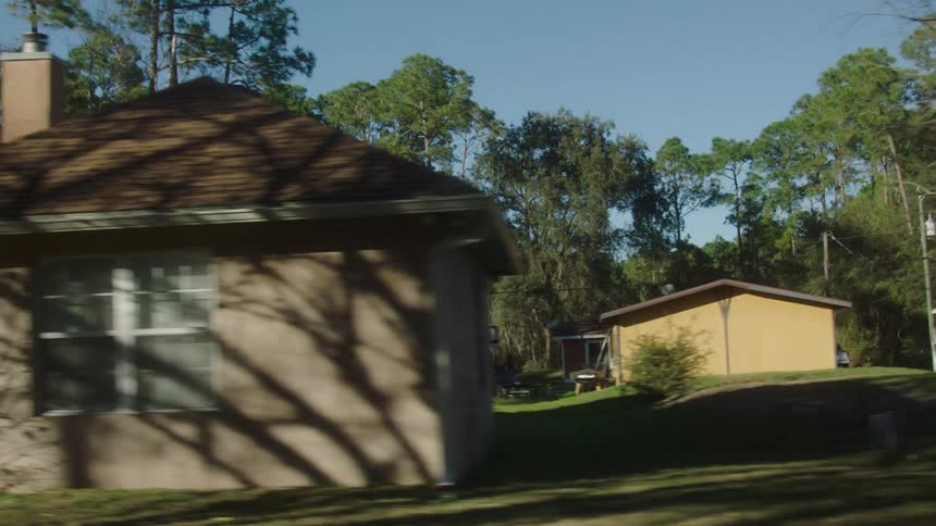 Vehicle drives through a residential neighborhood passing parked cars during the daytime