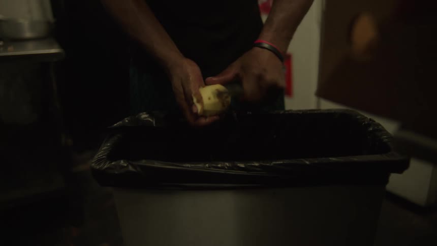 Pair of hands with a knife peeling a potato