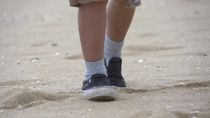 A child walks in sand