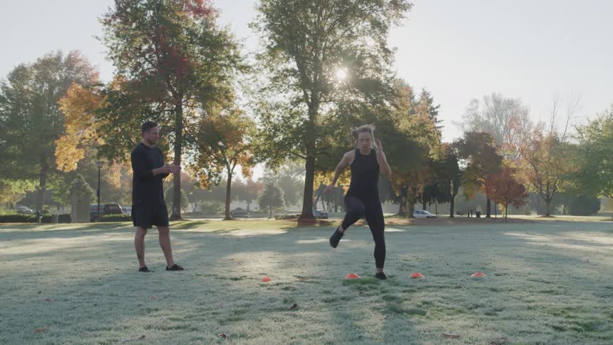 A man claps as a woman works out