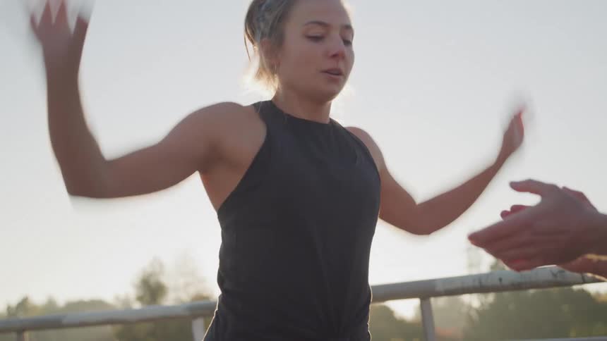 A couch is clapping for a woman doing jumping jacks