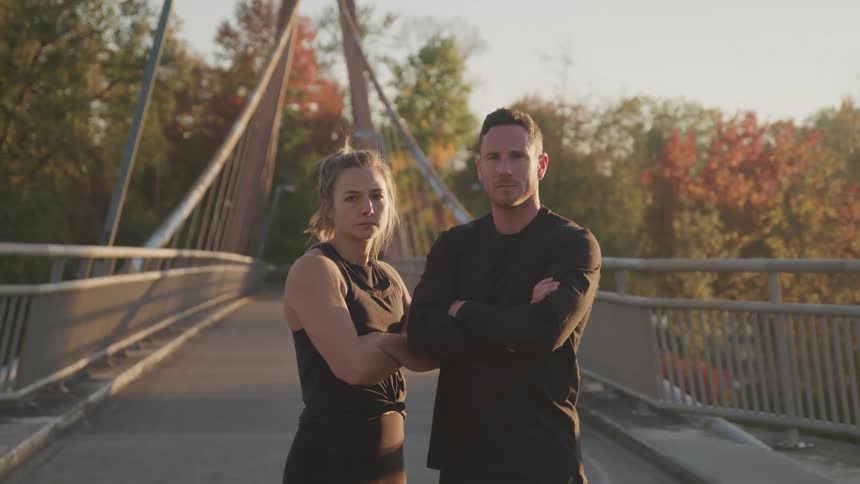 A man and woman are standing on the small bridge