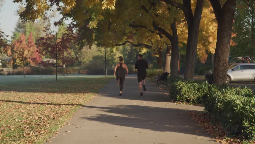 A man and woman run together in the park
