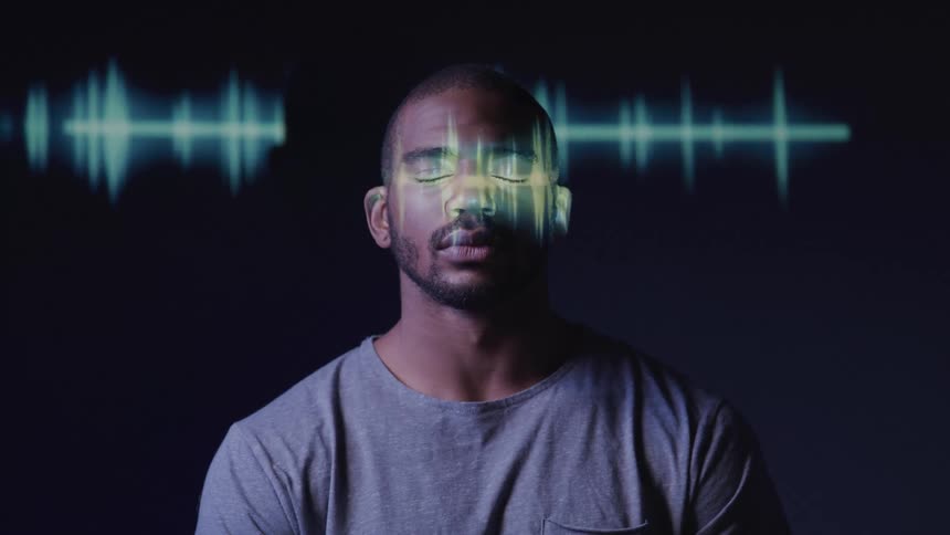 Projected light forms a pattern on the wall and the face of a man who closes his eyes