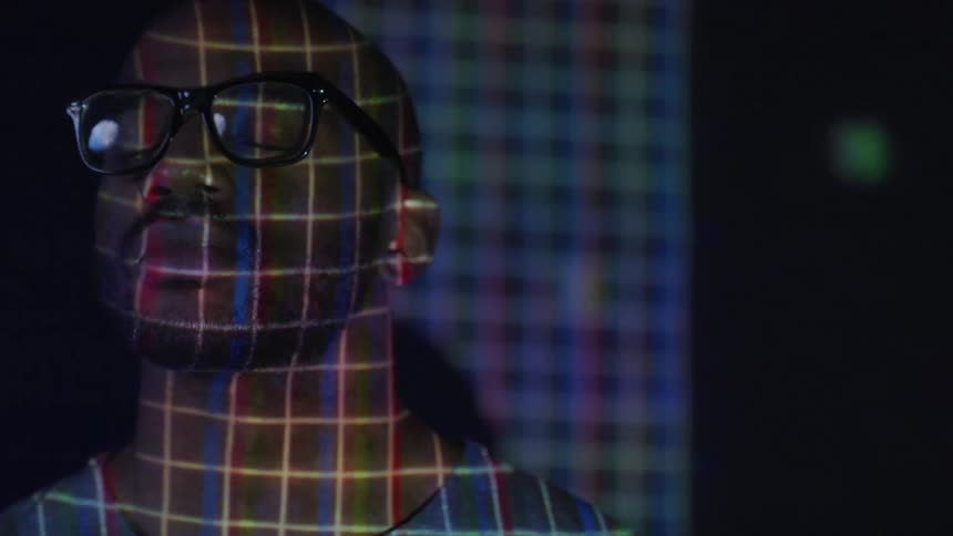 A man stands in front of a projection