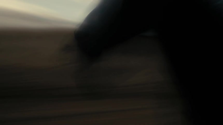 Blurry horse runs across the landscape under a cloudy sky