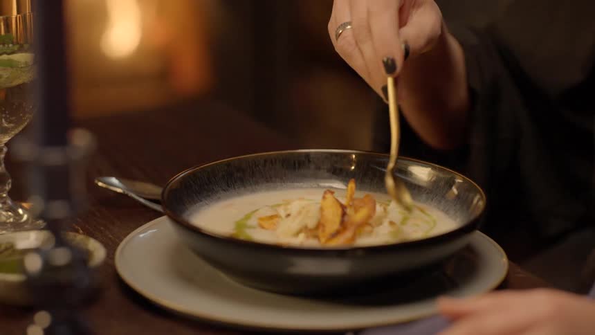 A woman puts sauce on her meal