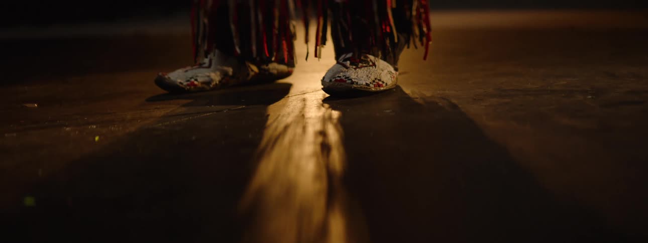 Tassels hang from the persons colorful costume