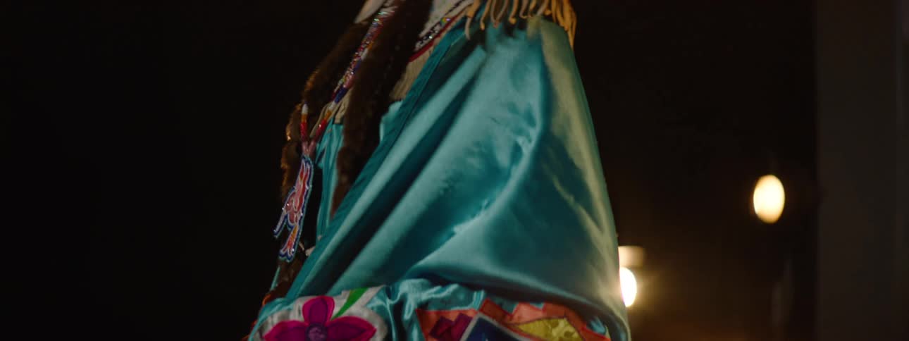 A woman walks on stage wearing a costume