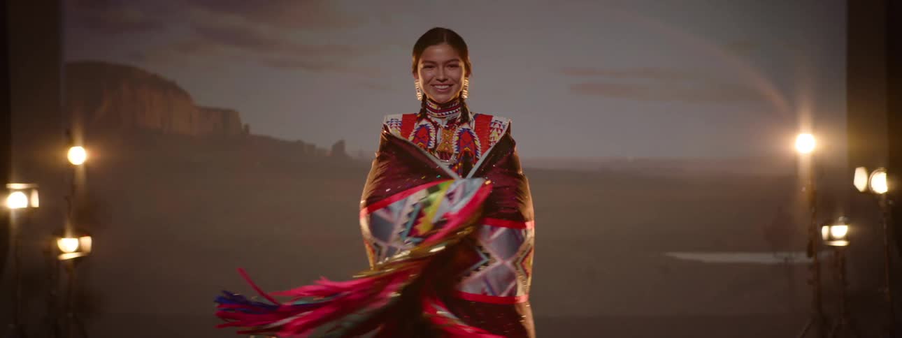 A girl smiles with her arms lifted