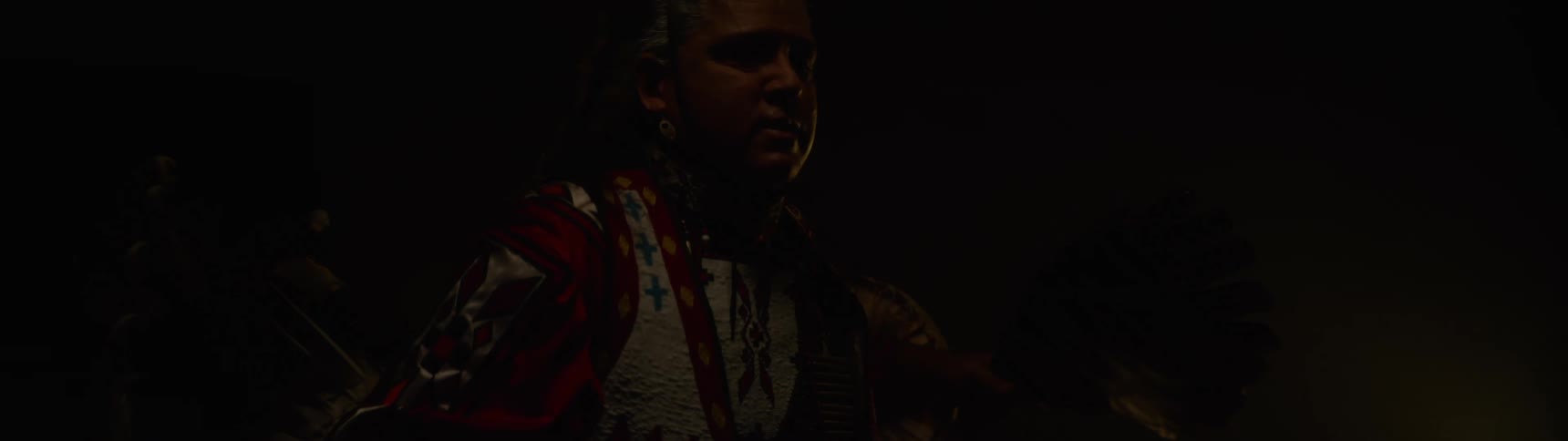Man in a lowlight environment wearing traditional attire