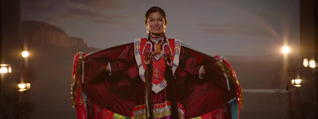 Smiling woman wearing traditional indigenous costume on a performance stage