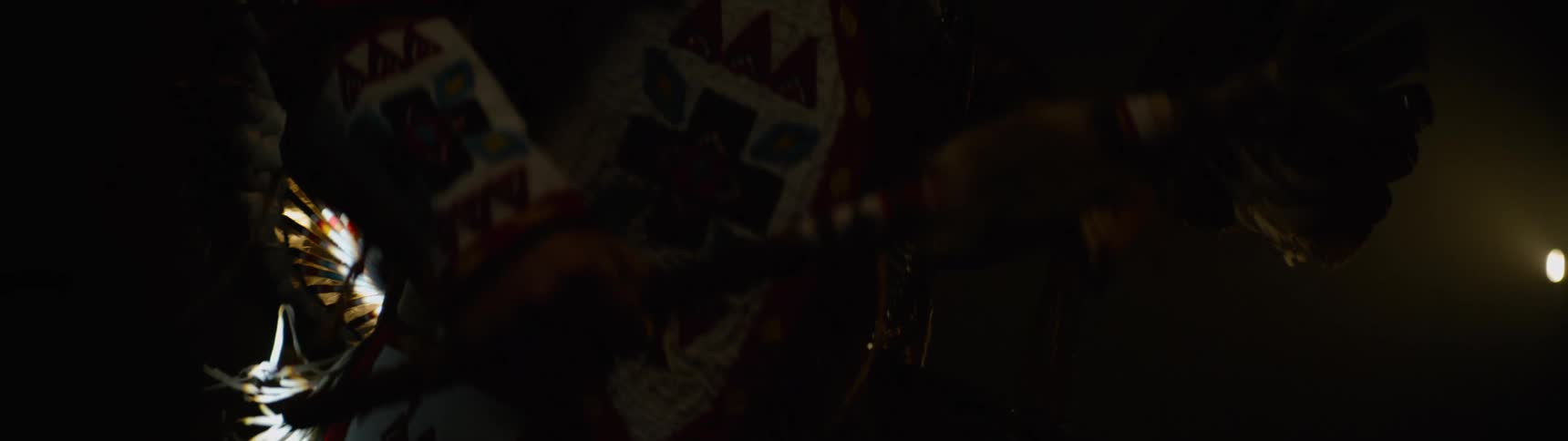 A man in a costume swings a scepter