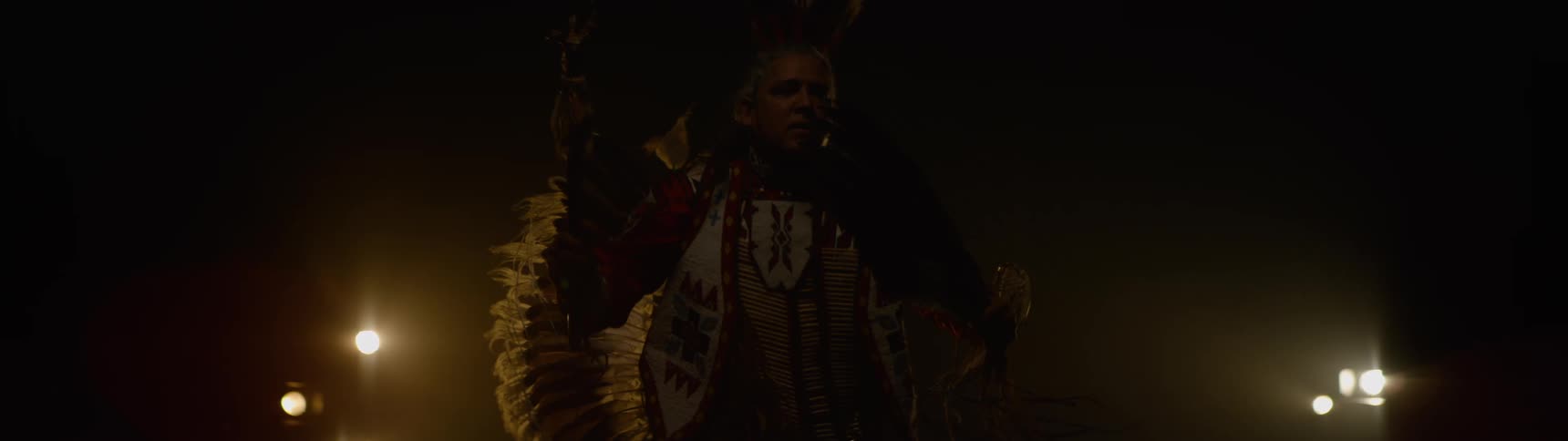 A man is wearing a costume with feathers
