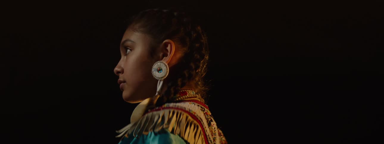 The girl is wearing tribal clothing on stage