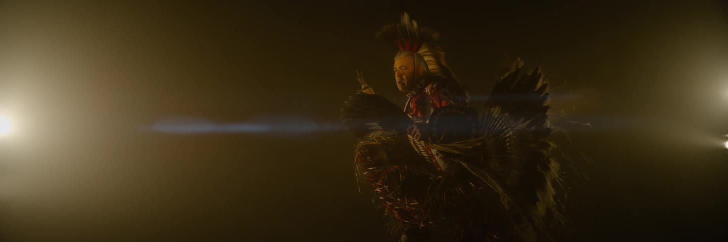 Person in traditional costume performing in a lowlight environment