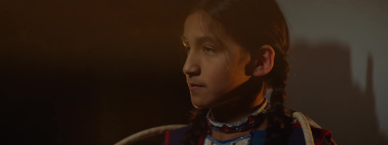 A native american girl wearing traditional indigenous clothes