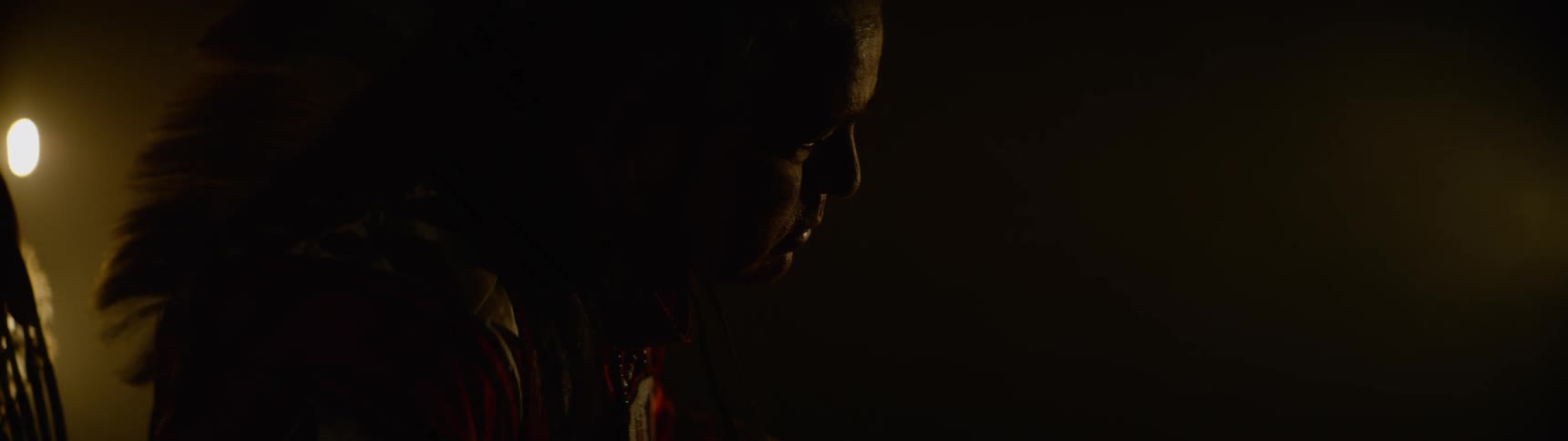 Man in a lowlight environment wearing traditional attire