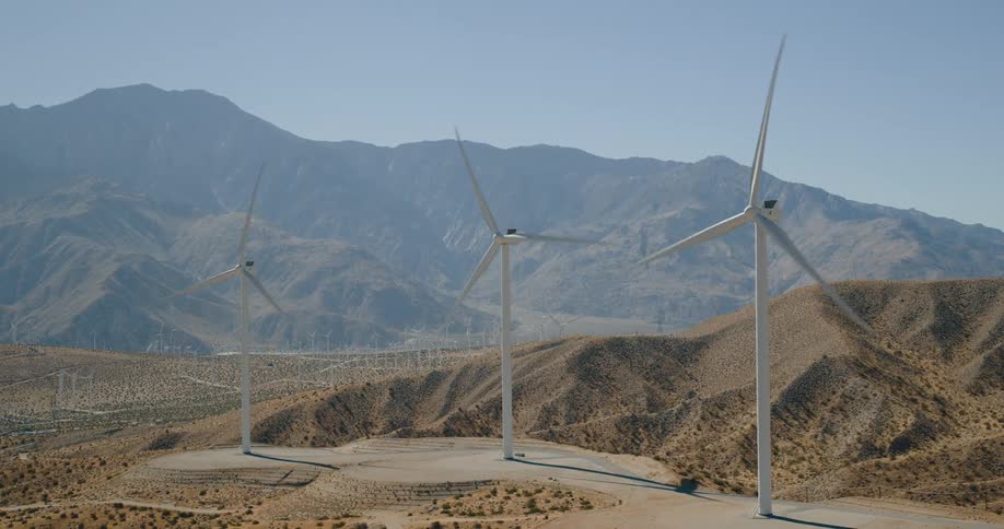 Wind turbines spin on a wind farm in the desert