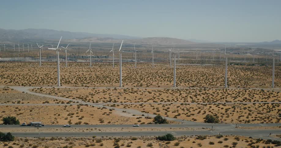 Wind turbines in a desert landscape with a highway in front