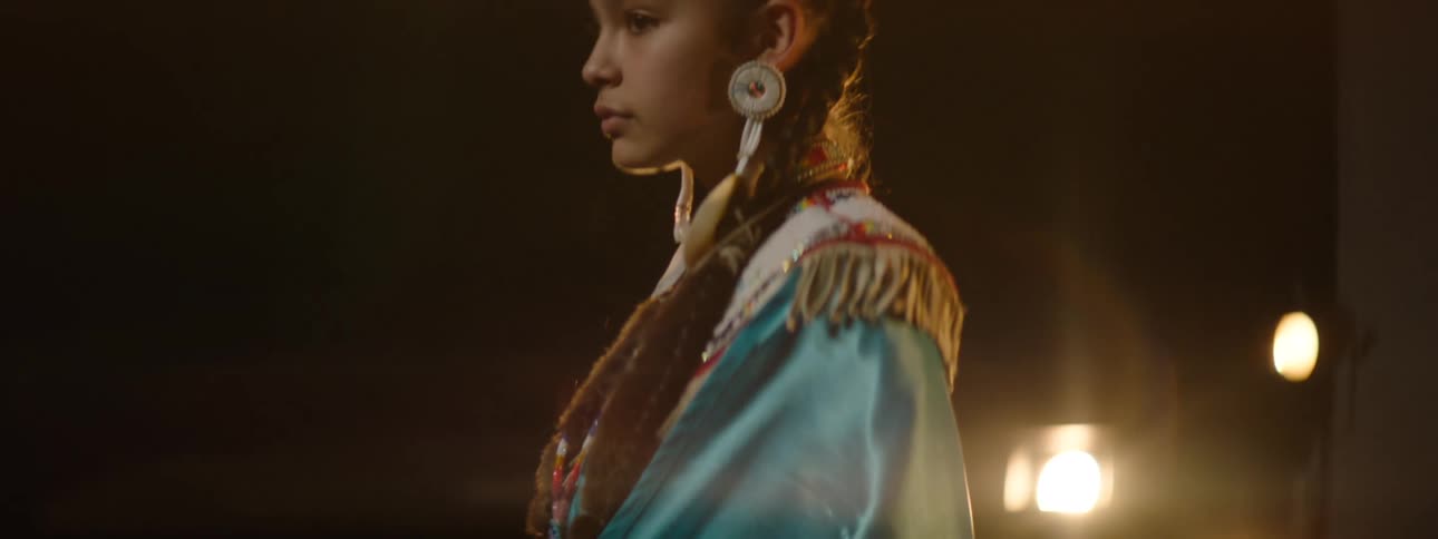 The girl is posing in tribal clothing on stage