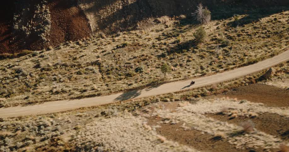 A motorcycle rides along a mountain road