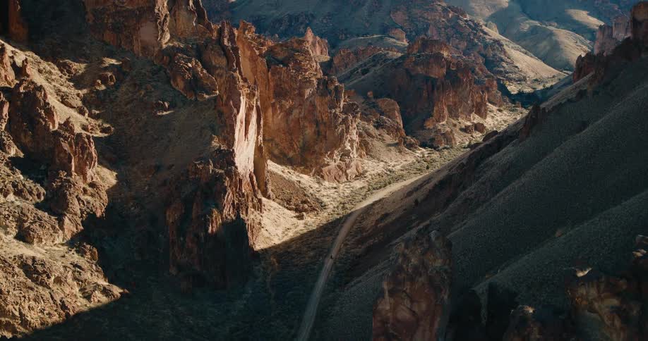 The vehicle travels on a trail in the middle of the mountains