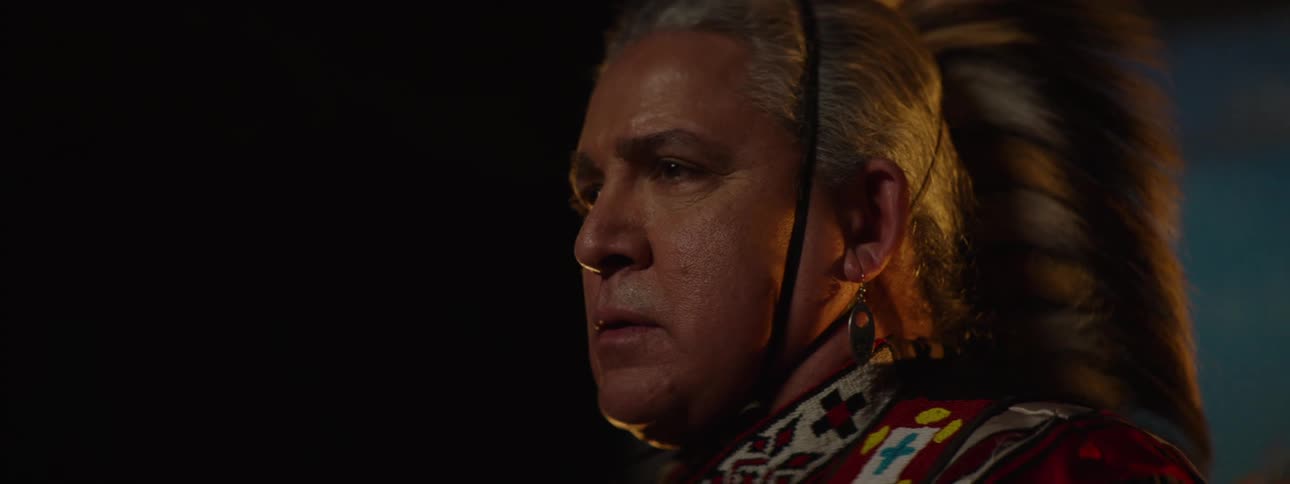 White haired man wearing traditional attire