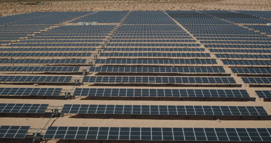 Rows of solar panels are lined up in the desert