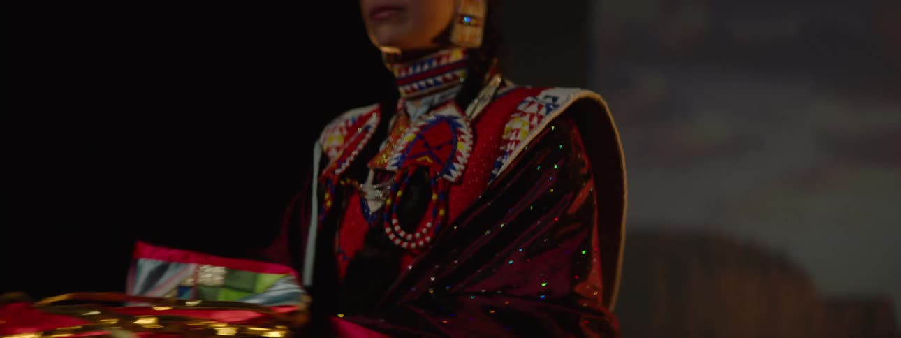 A woman dressed in indigenous clothing spins in a circle