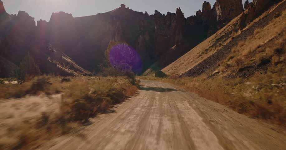 A freeway winding through a valley under the bright sun on a clear day