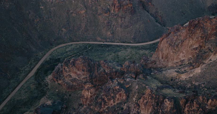 Aerial view of a mountain range with a road going through the middle