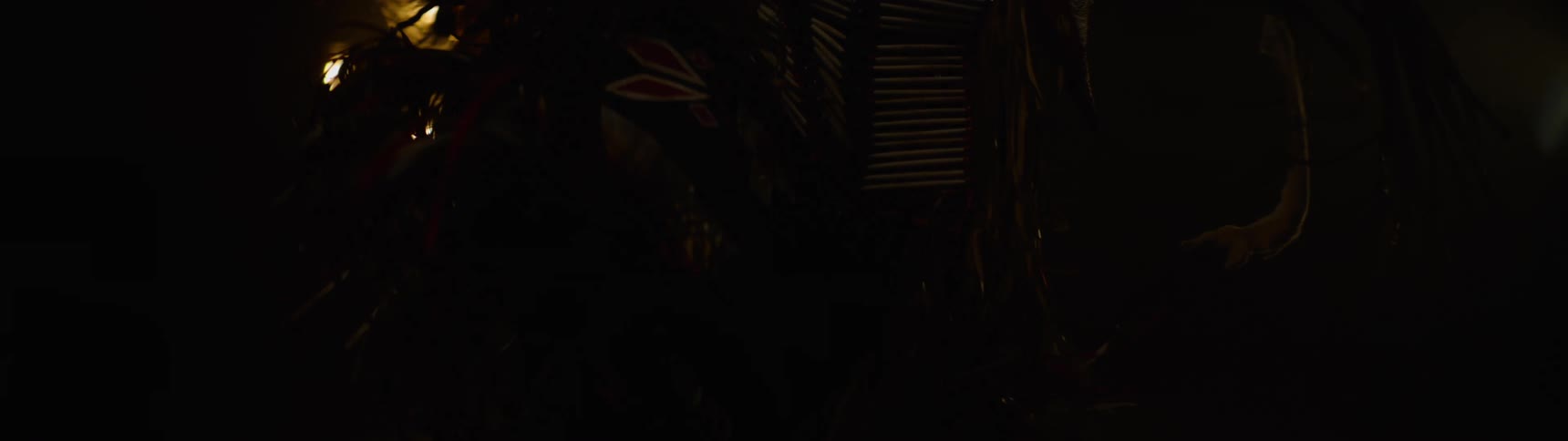 The person is dancing in the dark in costume