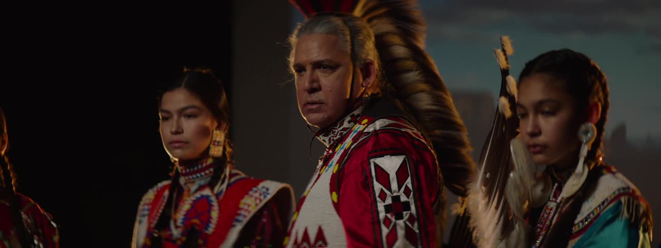 People are posing on stage wearing native costumes