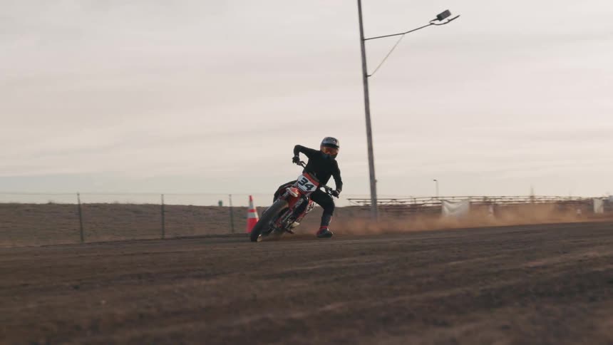 A man slides on his boot as he rides his dirt bike