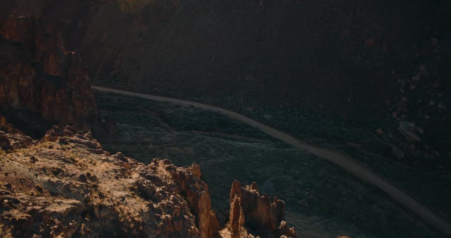 Aerial view of a highway between canyons and mountains