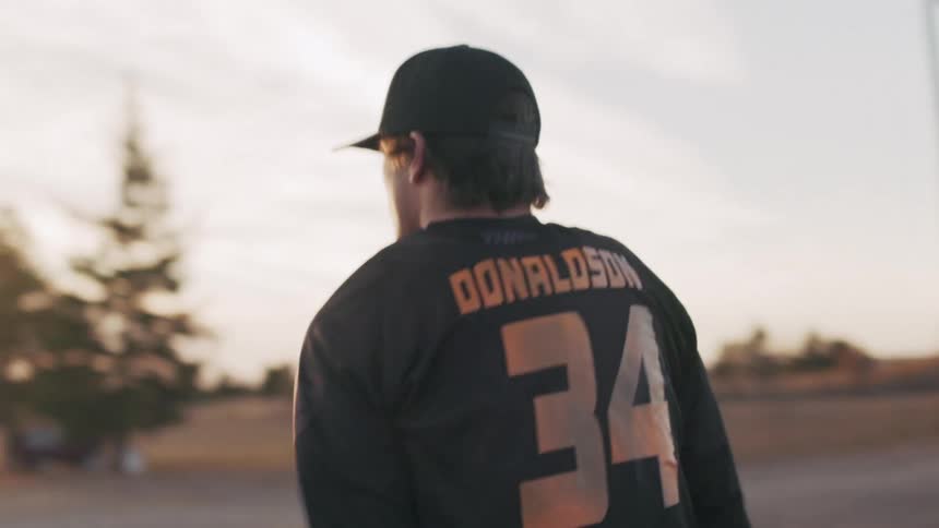 A man walks over to his dirt bike in the lot