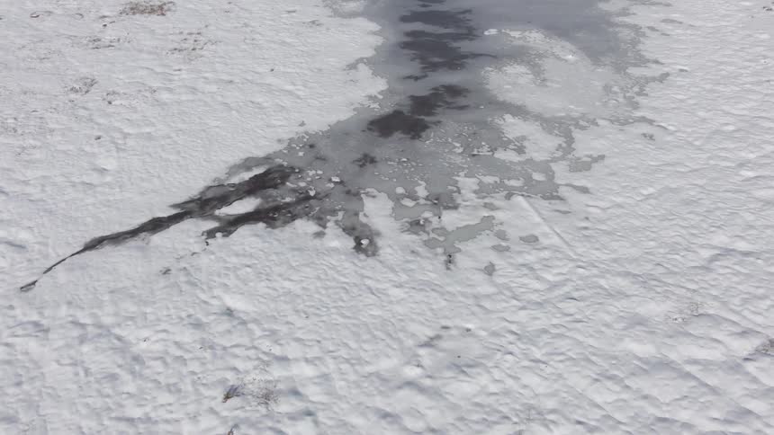 Aerial view of a frozen river in a snowy area