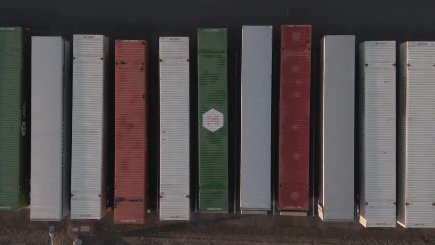 Different color shipping containers are side by side
