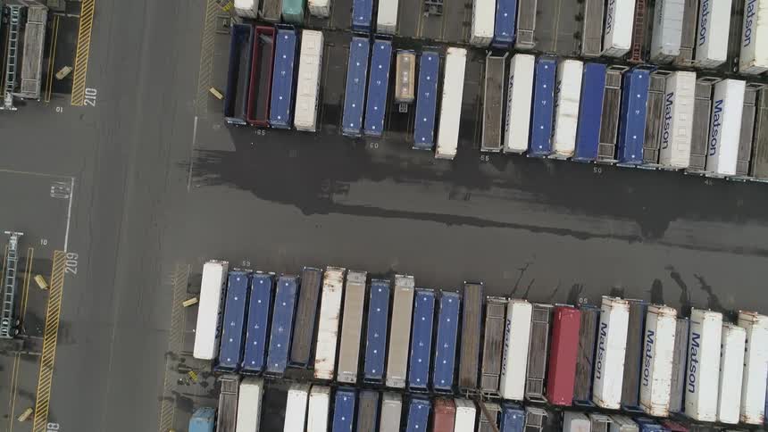 A seaport filled with shipping containers under the bright midday sun
