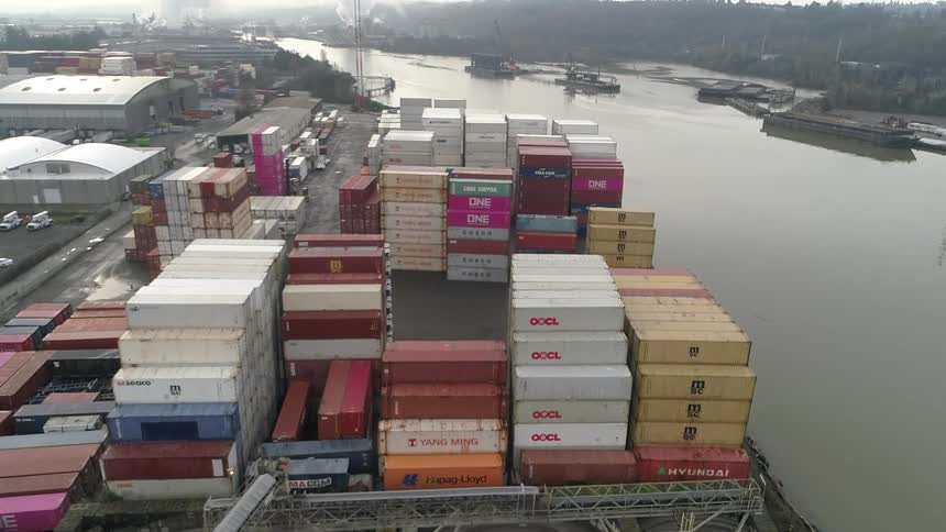 A seaport filled with stacked containers under the bright midday sun