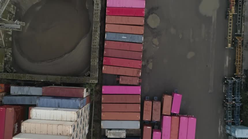 Aerial view of a shipping yard filled with colorful cargo containers arranged in rows