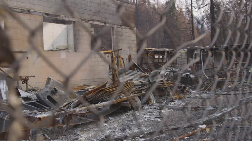 A deteriorated house and rusted burned debris