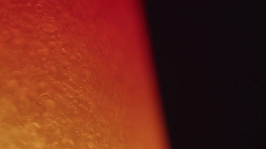 Abstract liquid with bubbles illuminated in orange color