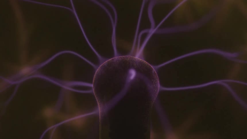 A glowing plasma ball emits numerous purple electrical tendrils from its center against a dark background