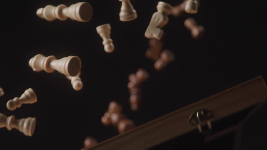 Wooden chess pieces are thrown into the air from their wooden box