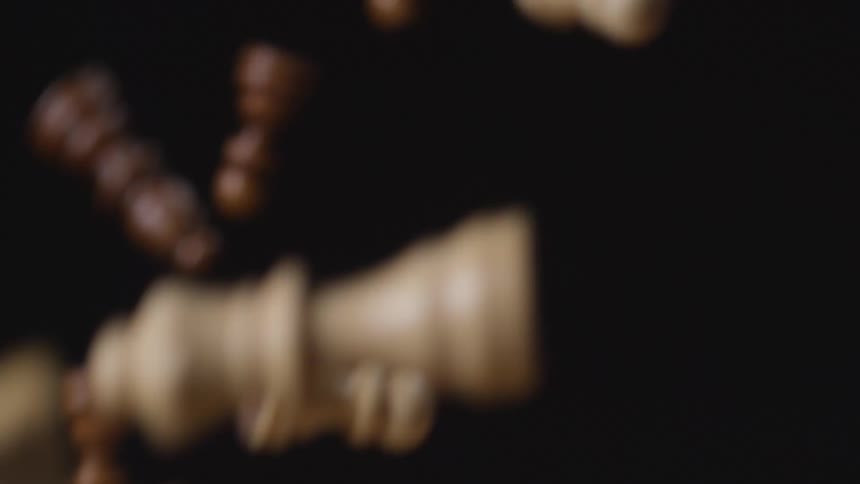 Chess pieces flying against a black background
