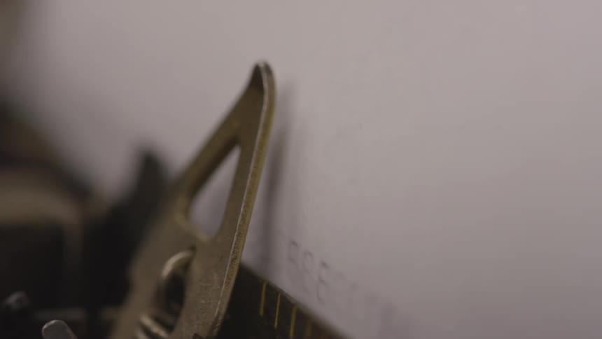 Close up of a typewriter in action typing on a white paper